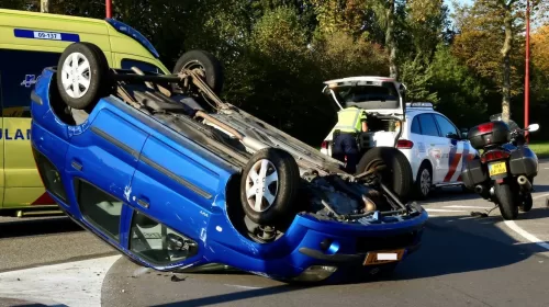 Twee auto’s met elkaar in botsing, een komt op zijn dak